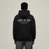 Person wearing a black hoodie with 'Lost at Sea' text on the back against a beige background