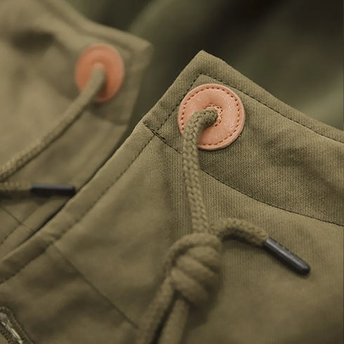 Close-up of a green jacket with buttons and a drawstring.