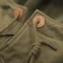Close-up of a green jacket with buttons and a drawstring.