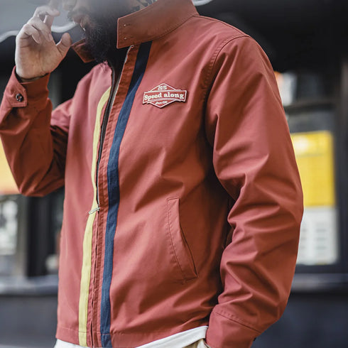 Person wearing a red jacket with a brand logo, blurred background