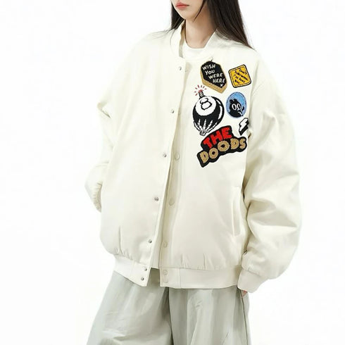 Person wearing a cream-colored jacket with colorful patches on a white background