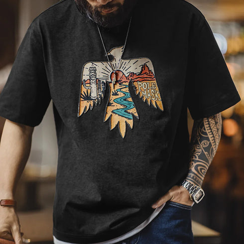 Person wearing a black t-shirt with a colorful graphic design on a blurred background