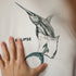 T-shirt with a fish design and 'Eclipse' branding, held by a hand.