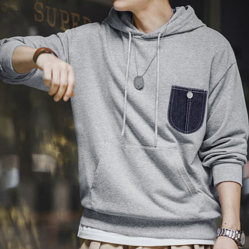 Casual Denim Pocket-Spliced Hoodie with grey fabric and contrasting denim pocket detail on chest, casual pullover style with hood and long sleeves.