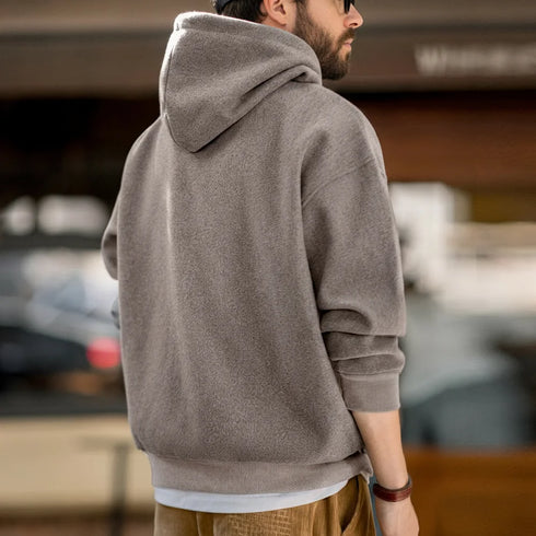Man wearing a gray hoodie in an urban setting