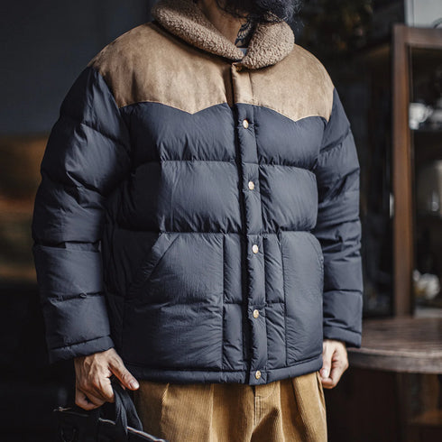 Person wearing a two-tone puffer jacket with dark blue front and brown collar and sleeves.