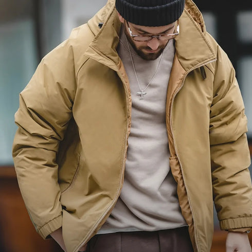 Man wearing beige hooded down jacket with zipper and black beanie outdoors