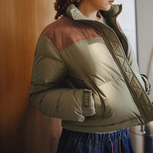 Person wearing a green and brown puffer jacket with a blurred background