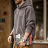 Man wearing vintage gray pullover hoodie with kangaroo pocket and adjustable hood holding magazine