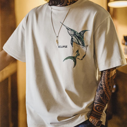 Person wearing a white t-shirt with a fish graphic and 'Eclipse' text, standing indoors.