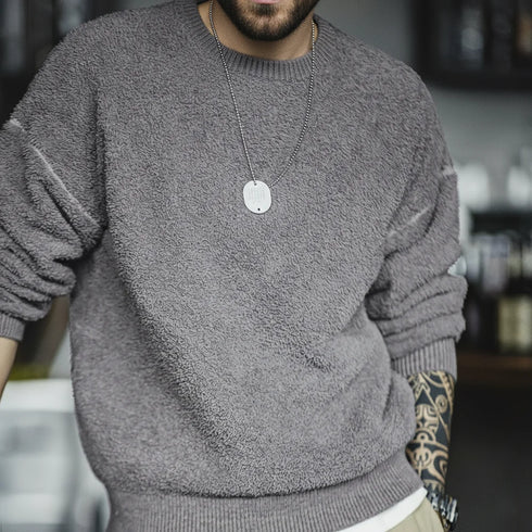 Person wearing a gray sweater with a blurred background