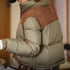 Person wearing a two-tone puffer jacket with a blurred background
