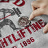 Gray t-shirt with red and black text and graphics, including a hand touching a badge.