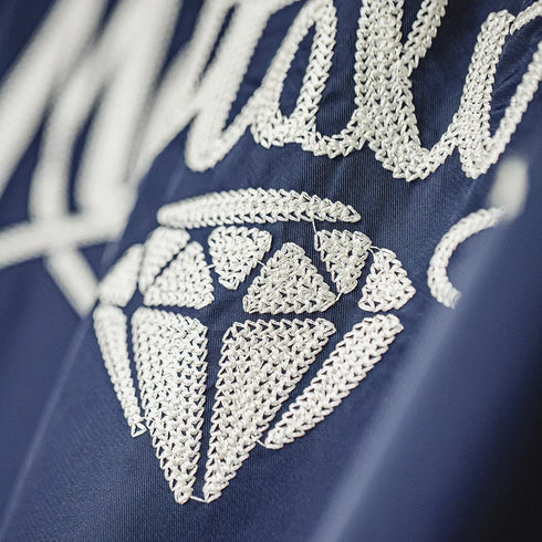 Close-up of embroidered design on a blue fabric background