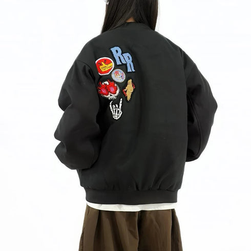 Black jacket with colorful patches on the back, worn by a person against a white background