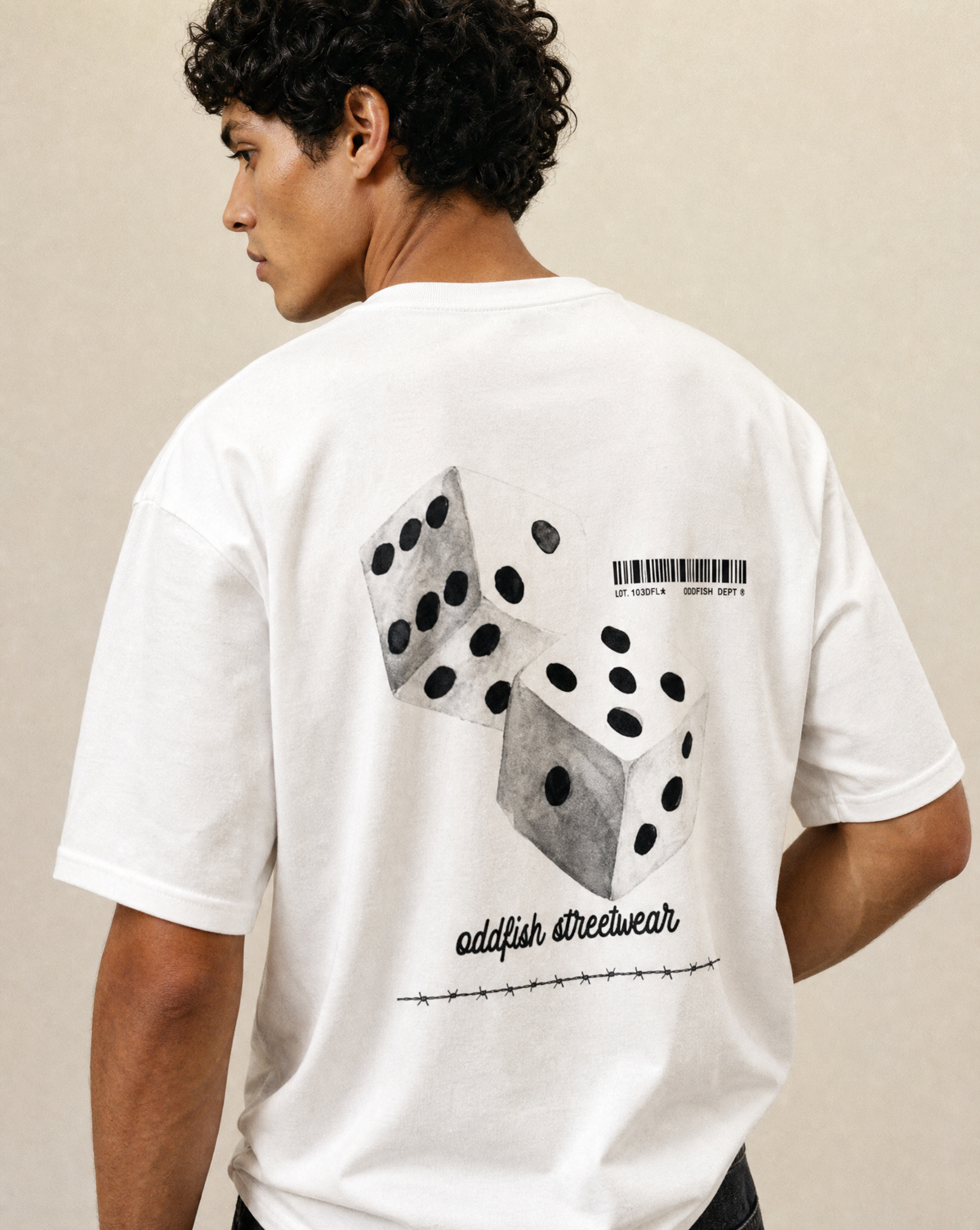 A man wearing a white t-shirt from the back, featuring a graphic print of two gray dice with black pips, a barcode, and the text 'oddfish streetwear' on a beige background.